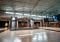 A large dinosaur skeleton exhibit is displayed in a spacious museum hall with a high ceiling. To the right, a video wall by Peerless-AV advertises an exhibition about minerals. The floor is tiled, and the space is well-lit with natural and artificial light.