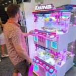 An attendee plays the Moon Station claw machine at the Guangzhou Credfort Import & Export Co. Ltd. exhibit.