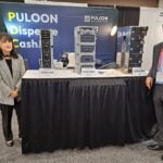 Serene Kim and Woohyun Park demonstrate banknote dispensing equipment at the Puloon Technology Inc. exhibit.